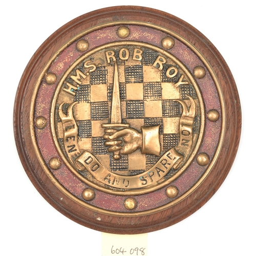 558 - A cast brass circular badge of HMS Rob Roy, destroyer 1916-26, showing crest of hand holding upright... 