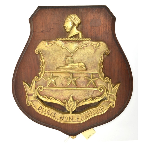 561 - A cast brass badge of HMS Sir John Moore, monitor 1915-21 showing an ornamental shield with 2 horizo... 