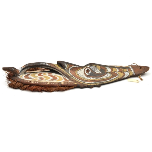 159 - A New Guinea (Sepik river area) wooden shield. Of elliptical form and carved with a stylised human m... 