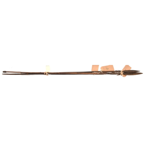 537 - 3 African fishing spears:  (a) blade 7½”, barbed socket, darkwood haft, 50” overall, (b) blade 7”, b... 