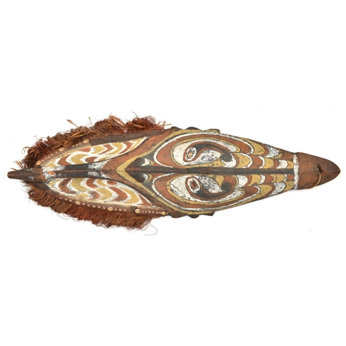 159 - A New Guinea (Sepik river area) wooden shield. Of elliptical form and carved with a stylised human m... 