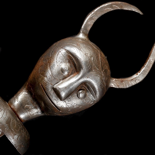 228 - A Persian all iron mace. 73cms, head embossed as a devil’s head with applied horns and bicycle bell-... 