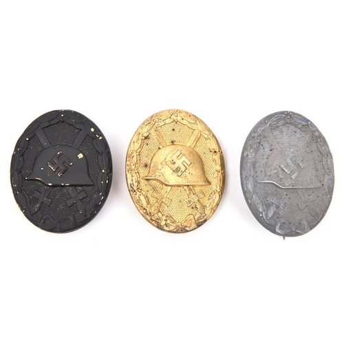 386 - Three Third Reich wound badges:  gold with solid back and “L/14” maker’s code; grey metal with solid... 