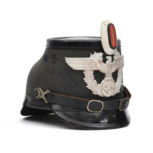 418 - A Third Reich Berlin police shako,  of black fibre with patent leather trim, aluminium eagle badge a... 