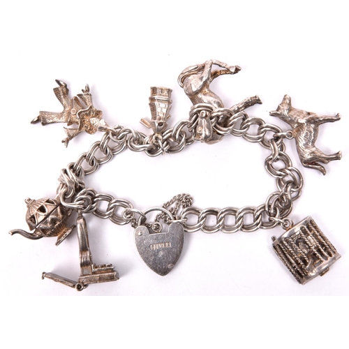 157 - A silver coloured charm bracelet, double link chain, with tiny stage and 3 dancing girls with movabl... 