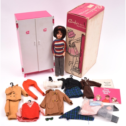 114 - A Sindy by Pedigee Doll Ltd. An early doll in striped jumper and jeans. Together with a boxed wardro... 