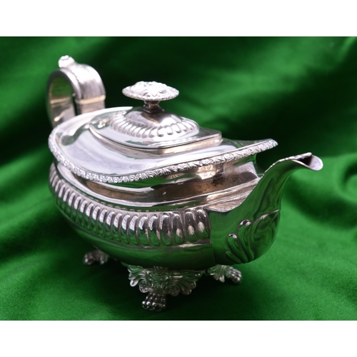 35 - A Georgian rounded rectangular silver teapot with gadrooning decoration to the body, leaf-embossed s... 