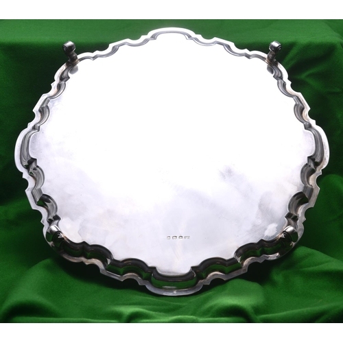 58 - A substantial silver tray on four scrolled feet with decorative raised edge. Hallmarked for Sheffiel... 