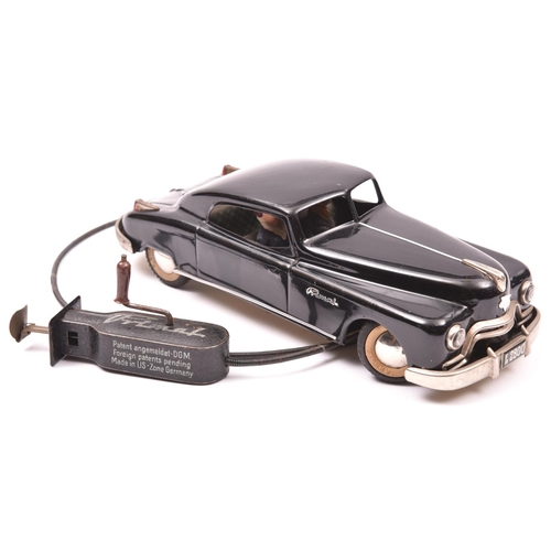 129 - An Arnold Tinplate 2 Door Saloon FB2800. A hand-held coil wire driven example finished in black with... 