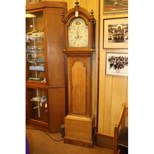 5 - An oak cased longcase clock. Early 19th Century clock striking on a bell with an arched painted face... 