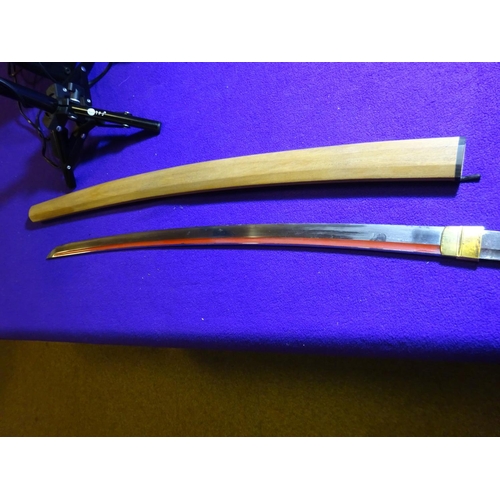 266 - A katana blade in shirasaya,  with full length grooves, red lacquered running down into the O-suriag... 