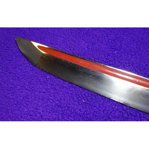 266 - A katana blade in shirasaya,  with full length grooves, red lacquered running down into the O-suriag... 