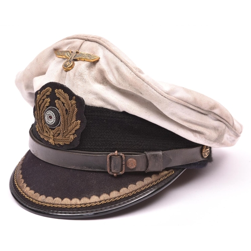 74 - A Third Reich Naval officer's white top peaked cap, with bullion badge and brass eagle, and maker's ... 