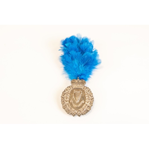 159 - A post 1953 London Irish Rifles piper's silver plated Caubeen badge; and companion blue feather hack... 