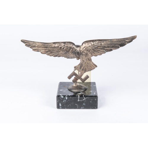 45 - A Third Reich Luftwaffe desk ornament, in the form of a white metal Luftwaffe eagle mounted on a rec... 