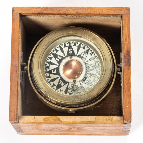 14 - A Ship's brass compass by Norie & Wilson, London. Mounted on a gimball in a wooden box with sliding ... 