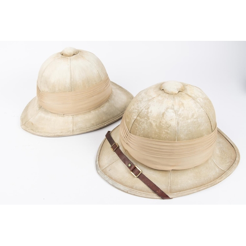 394 - 2 khaki coloured Wolsely helmets, with leather chinstraps. £50-60