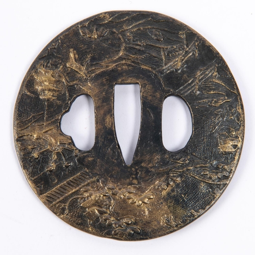 362 - A Japanese cast brass tsuba, blackened on  one side and embossed overall with rural scene. GC £50-60