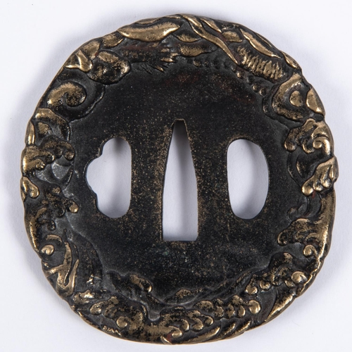 365 - A Japanese blackened cast brass tsuba, deeply embossed around the rim with entwined dragons. GC £50-... 