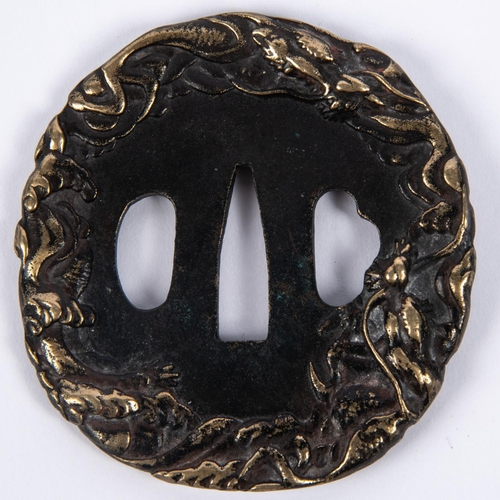 365 - A Japanese blackened cast brass tsuba, deeply embossed around the rim with entwined dragons. GC £50-... 