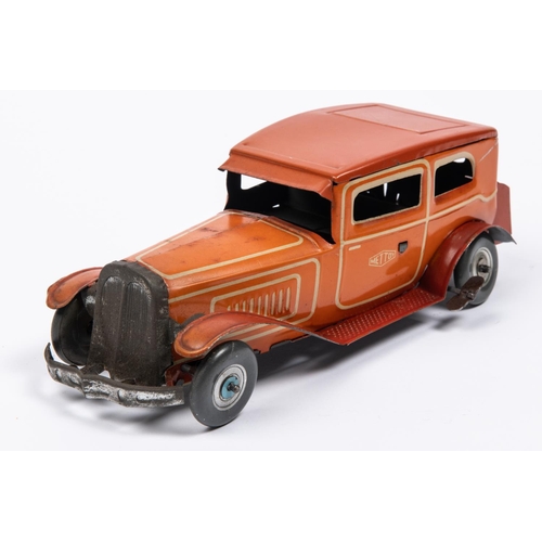 212 - A 1930's style Mettoy tinplate clockwork 2 door saloon car. In orangey red with cream line detailing... 