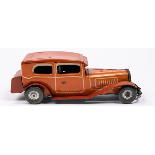 212 - A 1930's style Mettoy tinplate clockwork 2 door saloon car. In orangey red with cream line detailing... 