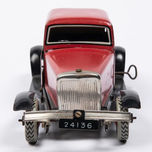 213 - A Chad Valley tinplate clockwork American style 2 seater saloon. Finished in red with black/silver l... 