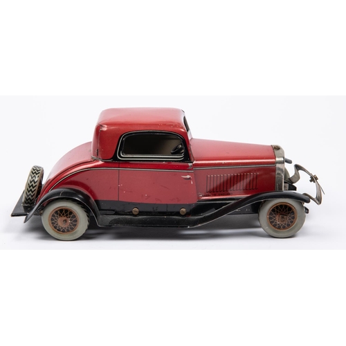 213 - A Chad Valley tinplate clockwork American style 2 seater saloon. Finished in red with black/silver l... 