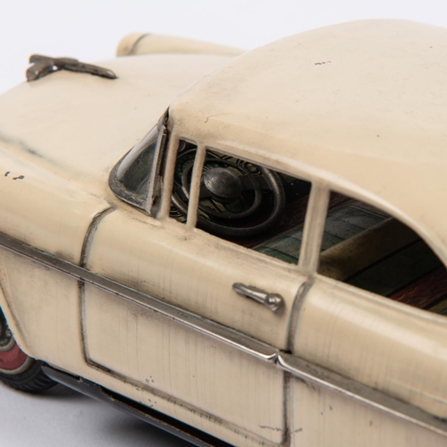 215 - A Japanese Asahi Toy Tinplate 2-door Sedan. A 1950s Ford Fairlane type car, in cream with red wheels... 