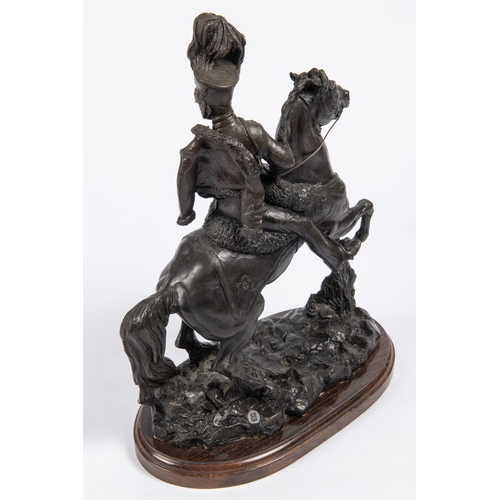 54 - A bronzed composition equestrian figure of an early 19th century French hussar  wearing shako with f... 