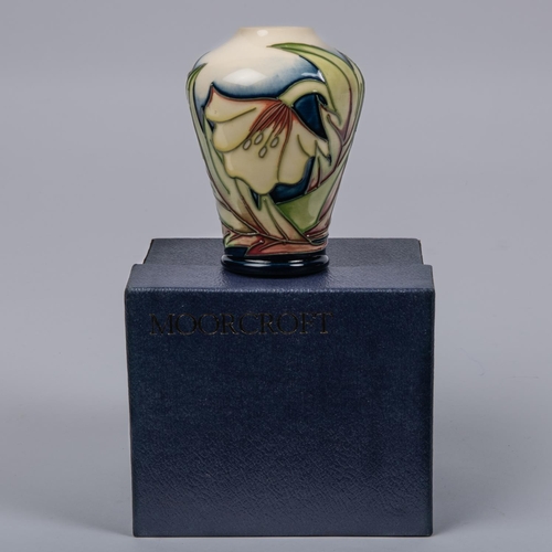 14 - A Moorcroft pottery miniature vase. With stylised floral design. Marks etc to base dated 2005 with p... 