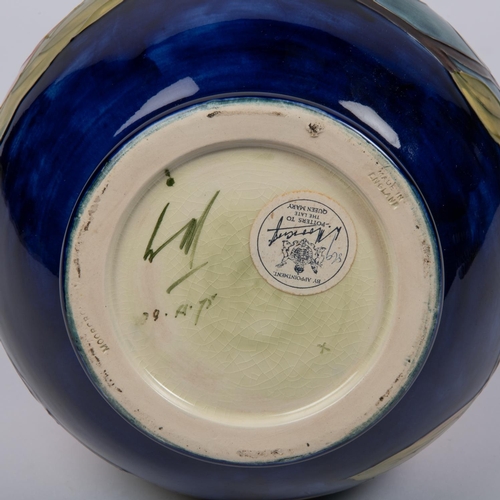 16 - A Moorcroft pottery vase. With magnolia design on a dark blue ground. Marks and sticker to base, dat... 