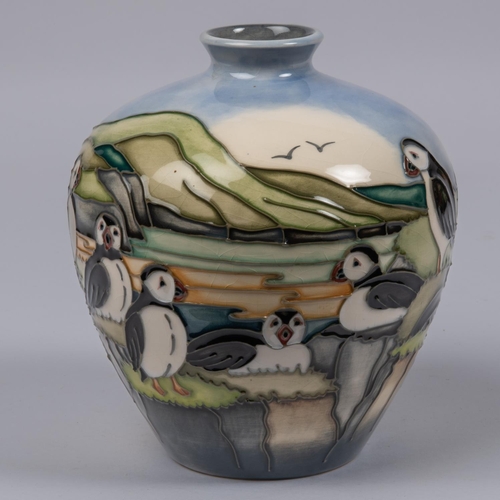 21 - A Moorcroft pottery vase. With puffins standing on a clifftop scene designed by Kerry Goodwin. Marks... 