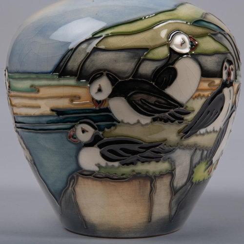 21 - A Moorcroft pottery vase. With puffins standing on a clifftop scene designed by Kerry Goodwin. Marks... 