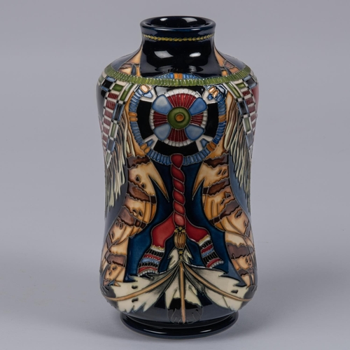 25 - A Moorcroft pottery vase. With Native American decoration on dark blue ground. Marks to base, PH, mu... 