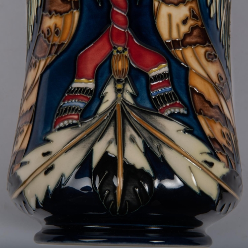 25 - A Moorcroft pottery vase. With Native American decoration on dark blue ground. Marks to base, PH, mu... 