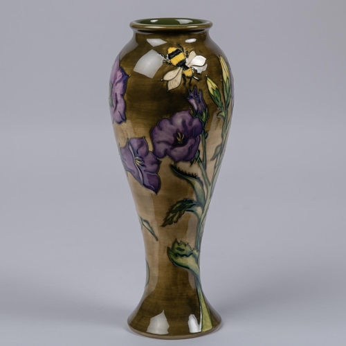 27 - A Moorcroft pottery slim vase. Bees with flowers on graded green ground. Marks to base, leaf date cy... 