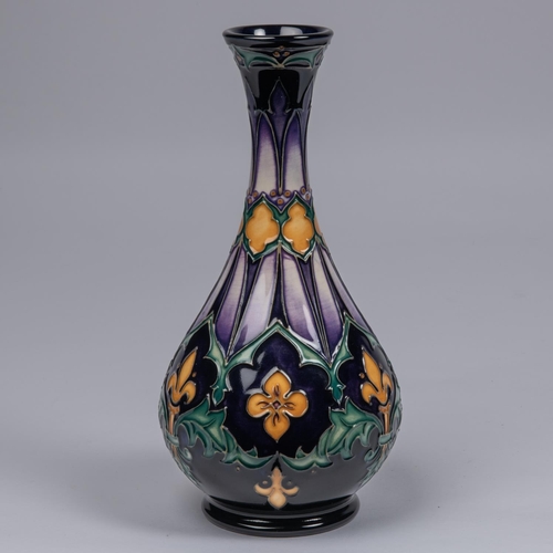 32 - A Moorcroft pottery vase. With fleurs-de-lys and acanthus leaf design on dark purple ground. Marks t... 