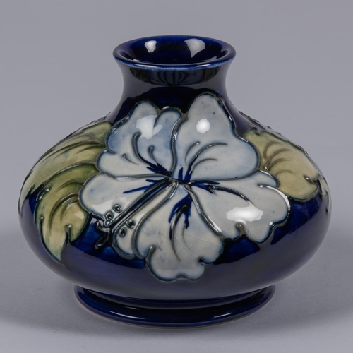 35 - A Moorcroft pottery vase. Earlier floral design by Walter Moorcroft on a dark blue ground. Impressed... 