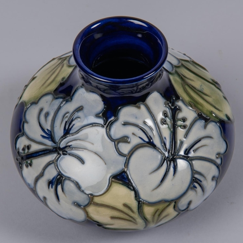 35 - A Moorcroft pottery vase. Earlier floral design by Walter Moorcroft on a dark blue ground. Impressed... 