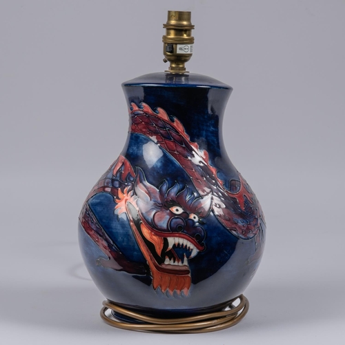 36 - A Moorcroft pottery lamp vase. With Chinese dragon on dark blue ground. Impressed marks to base. H.3... 