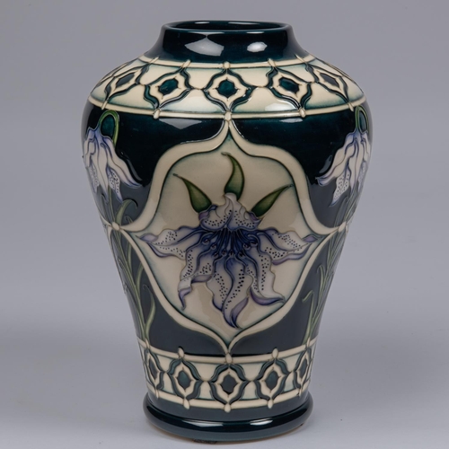 48 - A Moorcroft pottery vase. With lily design on dark blue ground by Marie Penkethman. Impressed marks ... 