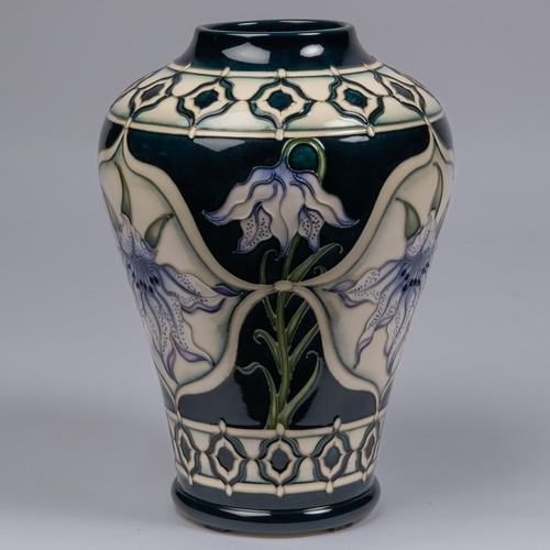 48 - A Moorcroft pottery vase. With lily design on dark blue ground by Marie Penkethman. Impressed marks ... 