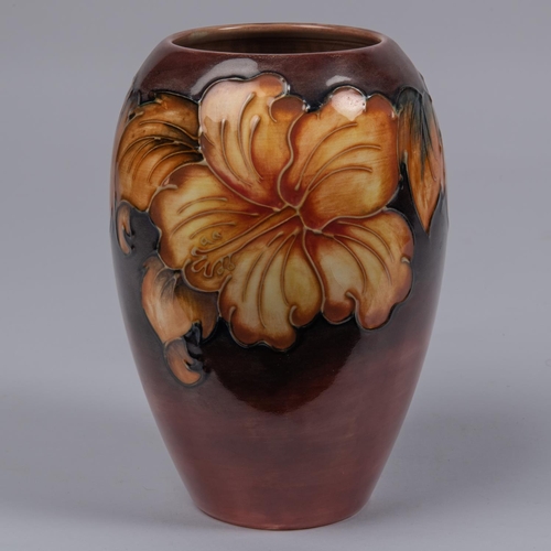 52 - A Moorcroft pottery vase. Galdioli type blooms on a graded ground. Marks to base, GP, bell date cyph... 