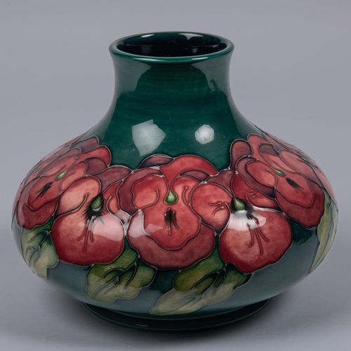 55 - A Moorcroft pottery vase. Purple flowers on a green ground. Marks to base, TRIAL, CS and flag date c... 