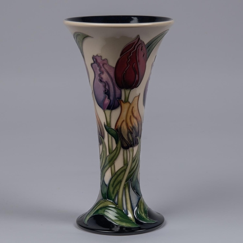 57 - A Moorcroft pottery vase. Tulips on a cream and dark blue ground by Rachel Bishop. Marks to base, AY... 