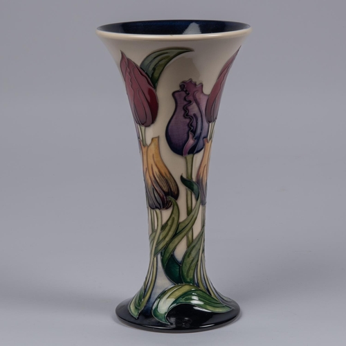 57 - A Moorcroft pottery vase. Tulips on a cream and dark blue ground by Rachel Bishop. Marks to base, AY... 