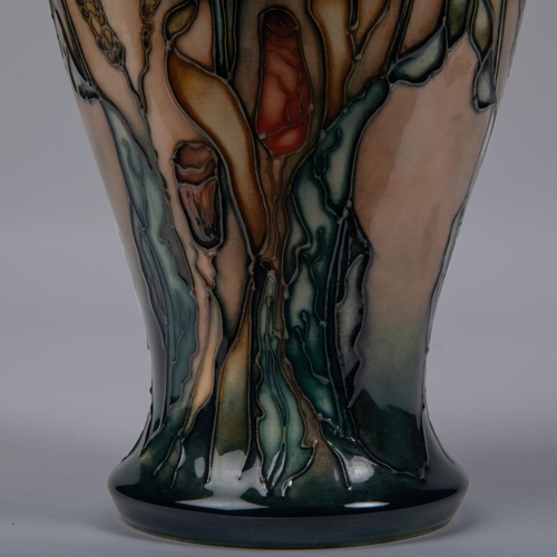 59 - A Moorcroft pottery vase. Stylised poppies on a graded green and peach ground. Marks to base, diamon... 