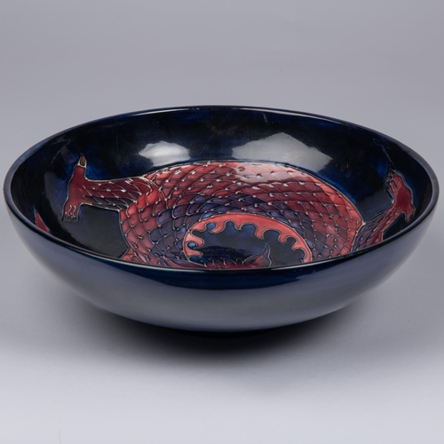 62 - A Moorcroft pottery bowl. Chinese dragon on a dark blue ground. Marks to base. W.260mm. VGC. £80-120