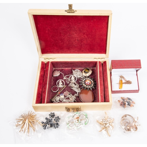 74 - A small box of costume jewellery. Including brooches, bangles, ring, locket, amber necklace, etc. So... 